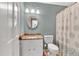 Well-lit bathroom features a granite vanity top, a toilet, and a shower with a floral shower curtain at 1406 Arden Sw Dr, Marietta, GA 30008