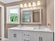 Well-lit bathroom with a double sink vanity, updated fixtures, and a large framed mirror at 1406 Arden Sw Dr, Marietta, GA 30008