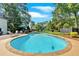 Enjoy the in-ground pool with a stone border and backyard with mature trees, a patio and lounge chairs at 1406 Arden Sw Dr, Marietta, GA 30008