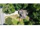 Aerial view showcasing the house, driveway, landscaping, and surrounding lush trees at 2015 Buford Dam Rd, Buford, GA 30518