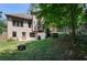 View of the backyard featuring a grassy slope, wooden fence, firepit, and stairs to the upper deck at 2015 Buford Dam Rd, Buford, GA 30518