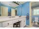 Bathroom featuring a vanity, sink and framed mirror with blue accent walls and trim at 2015 Buford Dam Rd, Buford, GA 30518