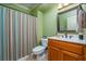 Bathroom featuring a wood vanity, sink and framed mirror with striped shower curtain at 2015 Buford Dam Rd, Buford, GA 30518