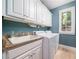 Well-lit laundry room with white cabinetry, granite counters, and appliances at 2015 Buford Dam Rd, Buford, GA 30518
