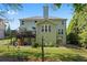 Stunning home's backyard featuring a deck, mature landscaping, and outdoor lighting at 2660 Brentwood Estates Ct, Cumming, GA 30041