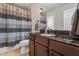 Bathroom features a dark granite countertop vanity, stylish faucet, tiled floors, and a shower with curtain at 2660 Brentwood Estates Ct, Cumming, GA 30041