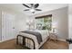 A cozy bedroom featuring a comfy bed, carpet, a ceiling fan, and a window with treelined view at 2660 Brentwood Estates Ct, Cumming, GA 30041