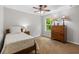 A well-lit bedroom with a cozy bed, carpet, and window offering natural light and a view of trees at 2660 Brentwood Estates Ct, Cumming, GA 30041