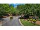 The gated entrance to the community includes a sign, mature landscaping, and flowering shrubs at 2660 Brentwood Estates Ct, Cumming, GA 30041