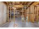 Unfinished basement featuring exposed wood studs, concrete floors, and utility lines overhead at 501 Highwater Pass, Canton, GA 30114