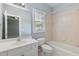 Bright bathroom with white vanity, tub-shower combo, and neutral tile at 501 Highwater Pass, Canton, GA 30114