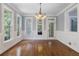 Bright dining room featuring hardwood floors, elegant chandelier, and natural light from large windows at 501 Highwater Pass, Canton, GA 30114