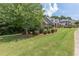 Exterior shot of a brick home with a vast green lawn, mature trees, and well-maintained landscaping at 501 Highwater Pass, Canton, GA 30114