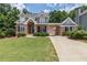 Charming brick home featuring a well-manicured lawn, arched entryway, and a convenient covered parking area at 501 Highwater Pass, Canton, GA 30114