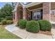 Close-up of a charming front porch featuring a brick facade and manicured round shrubs at 501 Highwater Pass, Canton, GA 30114