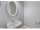 Powder room featuring a pedestal sink and oval mirror in a neutral color palette at 501 Highwater Pass, Canton, GA 30114