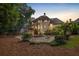 The back exterior of the home with a firepit, pool, screened porch, and lots of greenery at 510 Northland Ridge Ct, Sandy Springs, GA 30342