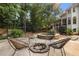 Outdoor entertaining space with fire pit and seating, stone accent wall and lush landscape at 510 Northland Ridge Ct, Sandy Springs, GA 30342