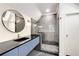 Stylish bathroom featuring modern vanity with a round mirror and a glass-enclosed shower at 510 Northland Ridge Ct, Sandy Springs, GA 30342