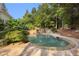 Backyard pool with stone trim and rock waterfall with lush green foliage and mature landscaping at 510 Northland Ridge Ct, Sandy Springs, GA 30342