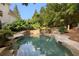 Beautiful backyard pool featuring a small waterfall feature and mature tropical landscaping at 510 Northland Ridge Ct, Sandy Springs, GA 30342