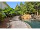 Lush backyard oasis pool with stone waterfall feature and mature landscaping surround at 510 Northland Ridge Ct, Sandy Springs, GA 30342