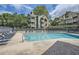 Community pool surrounded by lounge chairs and lush green trees at 578 Mcgill Ne Pl # 578, Atlanta, GA 30312