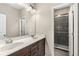 This bathroom features a double sink vanity, framed mirror, walk-in shower with glass doors and decorative tiling at 1370 Dupont Nw Park, Atlanta, GA 30318
