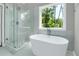 Serene bathroom with soaking tub, glass shower, and large window with tree views at 3439 Twin Village Ct, Snellville, GA 30039