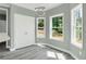A bedroom with wood-look floors, gray walls, a modern light fixture and bright natural light at 3439 Twin Village Ct, Snellville, GA 30039