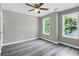Bright bedroom featuring hardwood floors, a ceiling fan, and natural light from two windows at 3439 Twin Village Ct, Snellville, GA 30039