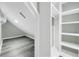 A spacious walk-in closet boasts ample storage with open shelving and a clothing rod, illuminated by modern lighting at 3439 Twin Village Ct, Snellville, GA 30039