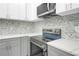 Modern kitchen featuring gray cabinets, white countertops, and stainless steel appliances at 3439 Twin Village Ct, Snellville, GA 30039