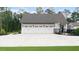 Detached three car garage with a concrete drive, white doors, and black carriage hardware at 604 Trinity Church Rd, Canton, GA 30115