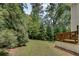 This backyard features a deck with a wooden railing, an expansive lawn, and an abundance of trees at 1823 Lynwood Ln, Atlanta, GA 30329
