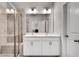 Bathroom featuring double sinks, white cabinets, tile floors, and a glass enclosed shower at 1823 Lynwood Ln, Atlanta, GA 30329