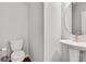 Elegant half bathroom with a pedestal sink, modern fixtures, and wood flooring at 1823 Lynwood Ln, Atlanta, GA 30329