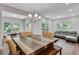 Bright dining area features a large wooden table, modern chandelier, and easy access to the living area and kitchen at 1823 Lynwood Ln, Atlanta, GA 30329