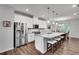 Open kitchen boasts a large island with seating, stainless steel appliances, and modern white cabinetry at 1823 Lynwood Ln, Atlanta, GA 30329