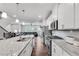 Modern eat-in kitchen featuring white cabinets, granite counters, stainless steel appliances, and open view to the living room at 1823 Lynwood Ln, Atlanta, GA 30329