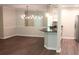 Open dining room boasts modern lighting, breakfast bar, and elegant wood flooring at 3501 Shepherds Path, Decatur, GA 30034