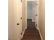 Hallway with dark laminate flooring and white trim molding showcasing access to another room at 3501 Shepherds Path, Decatur, GA 30034