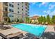 A clear blue swimming pool with lounge chairs and umbrellas with the building in the background at 230 E Ponce De Leon Ave # 116, Decatur, GA 30030