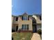 Charming townhome with tan facade, multiple windows, and a neatly maintained lawn at 2390 Coach Way, Jonesboro, GA 30236