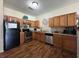 Well-lit kitchen with wooden cabinets, stainless steel appliances, and hardwood flooring at 2390 Coach Way, Jonesboro, GA 30236