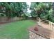Grassy backyard featuring a flower bed and a wooden fence, framed by mature trees at 360 Hannaford Dr, Roswell, GA 30075