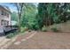 Landscaped backyard with a stone pathway leading to a deck and a wooded area at 360 Hannaford Dr, Roswell, GA 30075