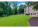 Exterior backyard featuring a playground, a lush green lawn and privacy trees at 360 Hannaford Dr, Roswell, GA 30075