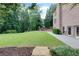 A large backyard view with healthy grass, a playset and perimeter trees at 360 Hannaford Dr, Roswell, GA 30075