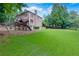 Expansive backyard featuring a lush lawn, play set, and a traditional brick home at 360 Hannaford Dr, Roswell, GA 30075